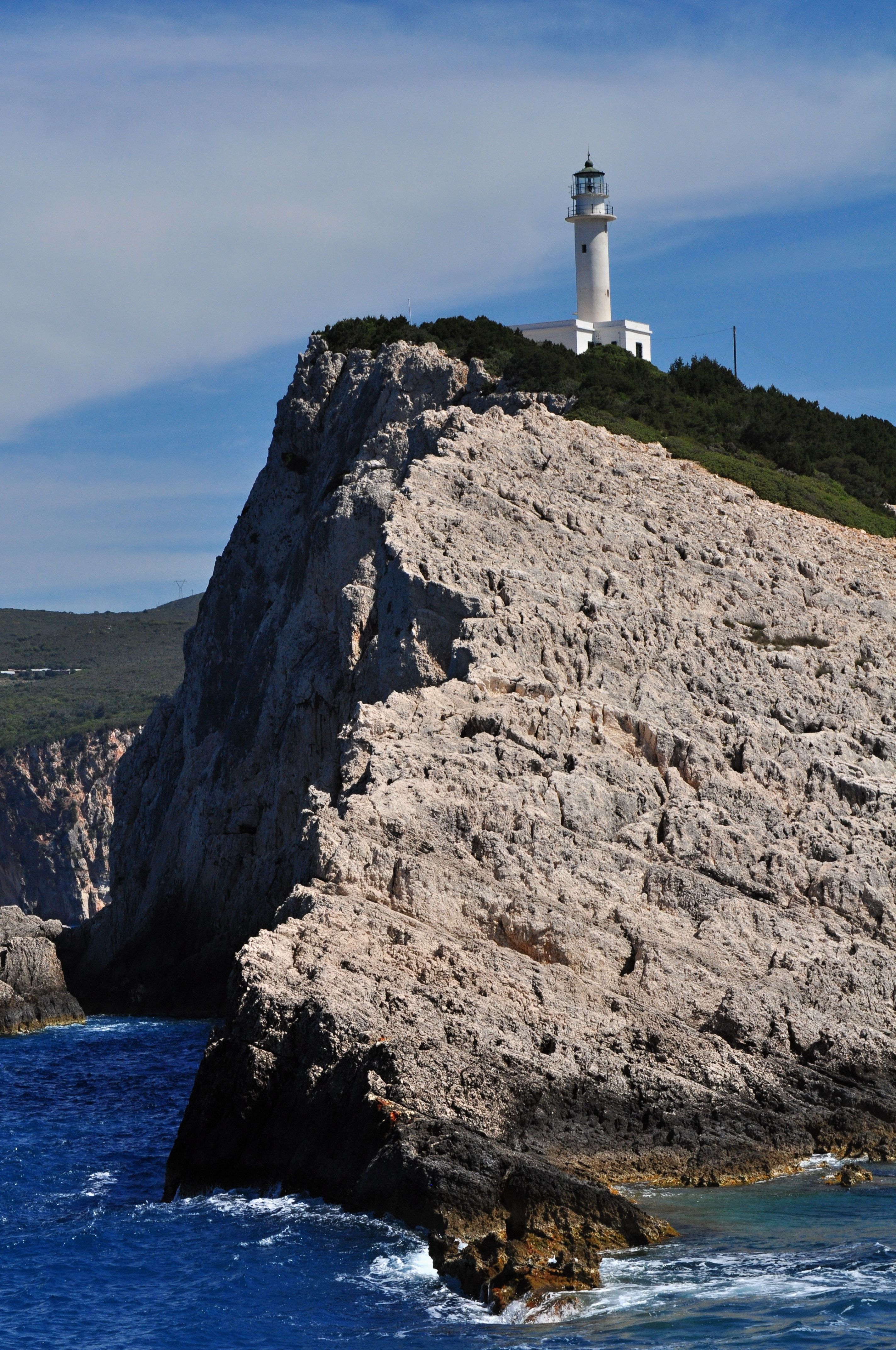 White and Red Lighthouse Near Body of Water · Free Stock Photo