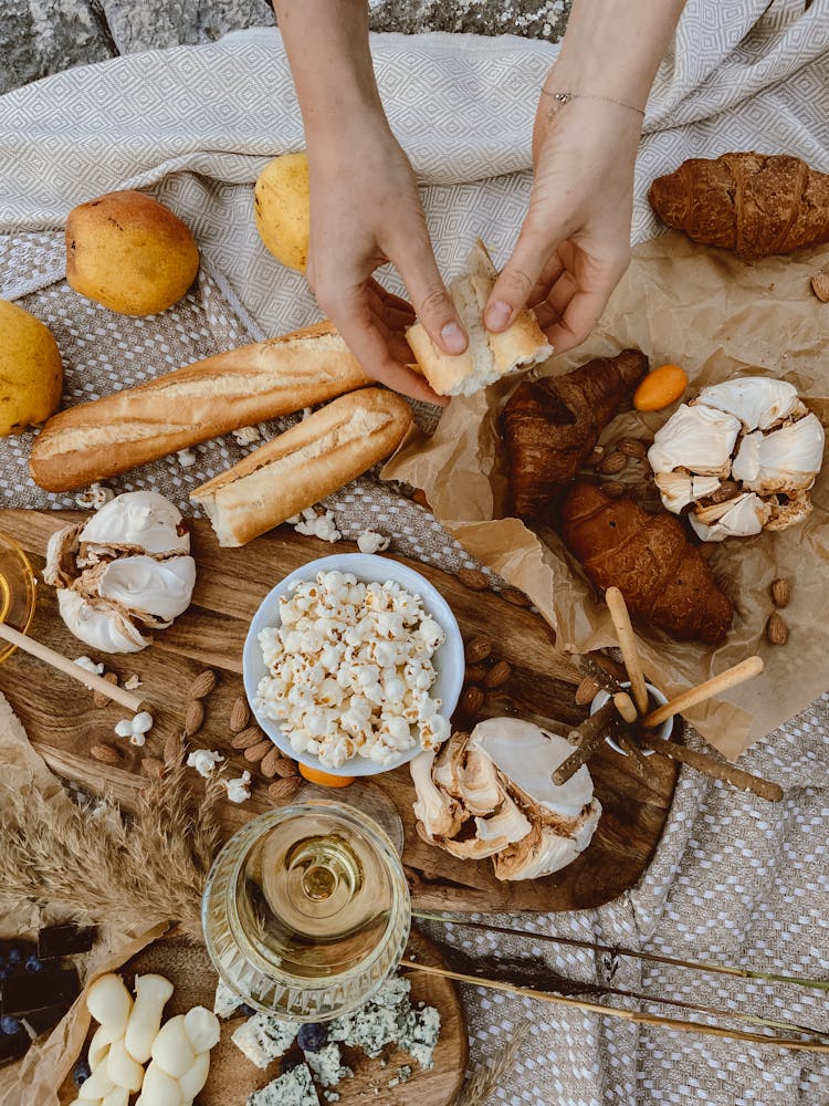 Hand Holding A Piece Of Baguette Bread