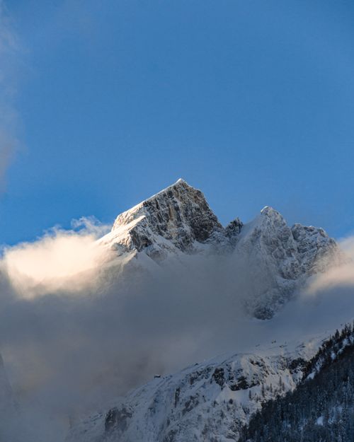 Free Majestic snow-covered mountain peak with blue sky and clouds in Slovenia. Stock Photo