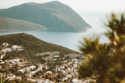 Free Picturesque coastal town surrounded by lush hills and serene sea, perfect for travel inspiration. Stock Photo