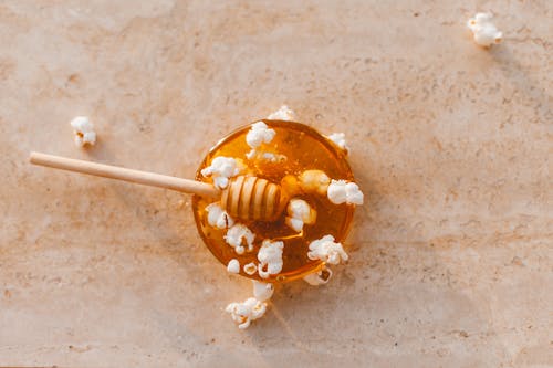 Popcorn and Honey on Marble Table Surface