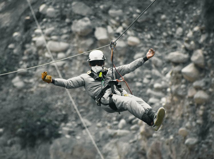 Courageous Man Hanging On Rope With Harness
