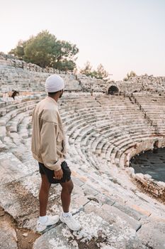 Man exploring an ancient stone amphitheater, capturing the essence of historic travel and adventure.