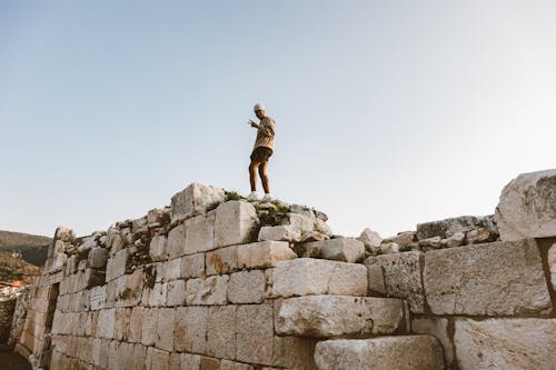 Free Man Standing on a Stone Wall Stock Photo