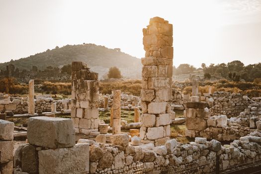 Explore the serene beauty of ancient ruins with towering columns at sunset, evoking history and tranquility.