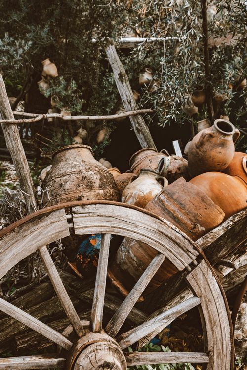 Free A rustic wooden cart filled with various earthenware pots in an outdoor setting. Stock Photo