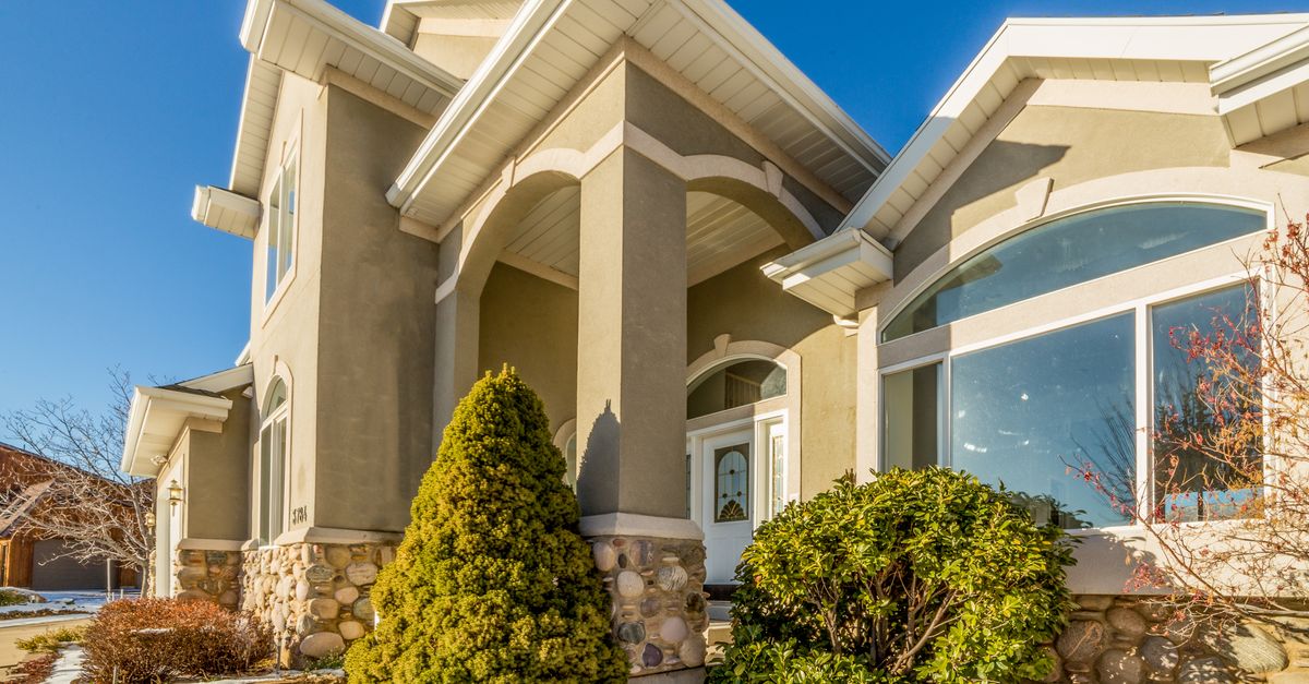 Bright and elegant exterior view of a modern suburban house with landscaped front yard.