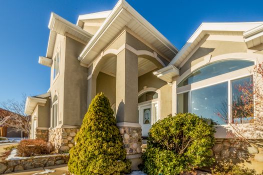 Bright and elegant exterior view of a modern suburban house with landscaped front yard.