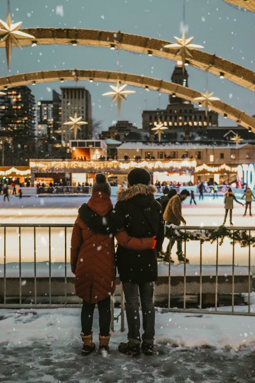 A Couple Watching Skaters in an Ice Rink