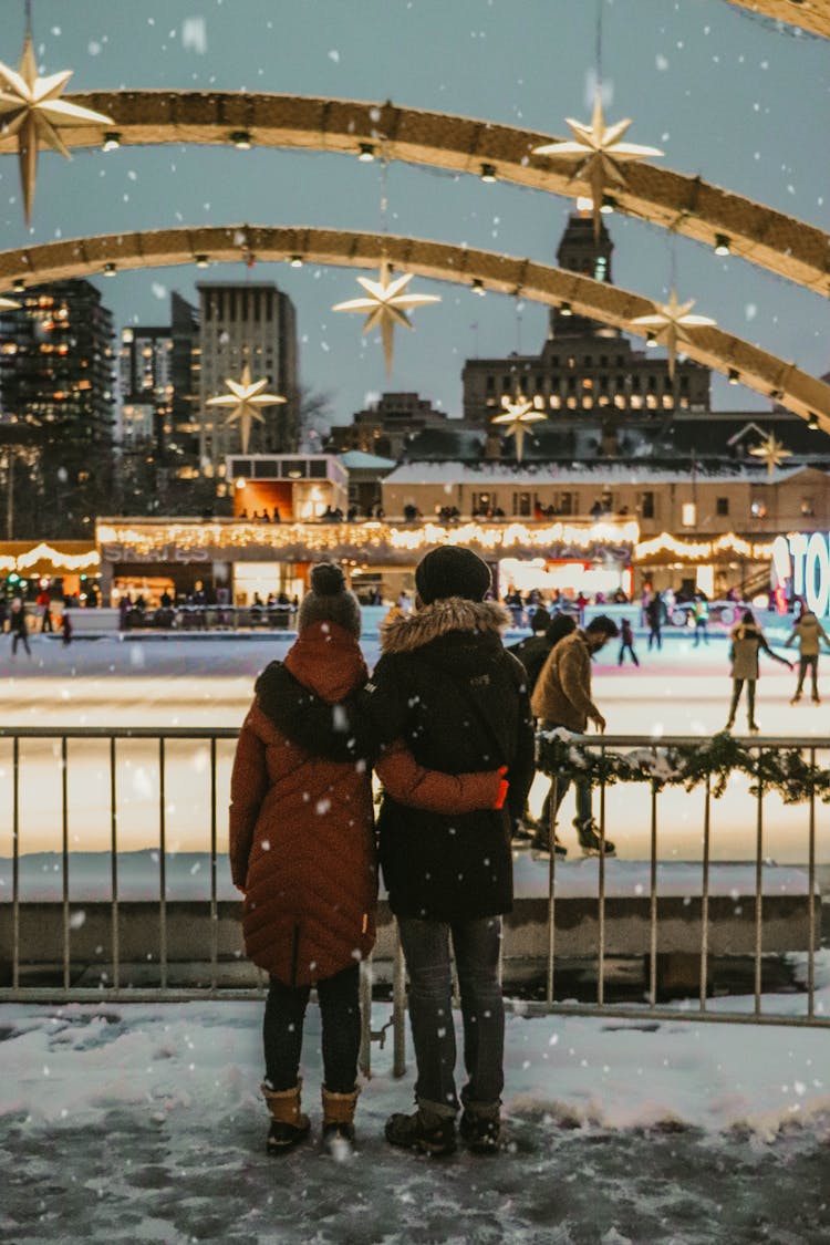 A Couple Watching Skaters In An Ice Rink