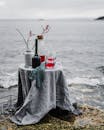 时尚的沿海餐桌布置，配有鸡尾酒和红色浆果，俯瞰大海