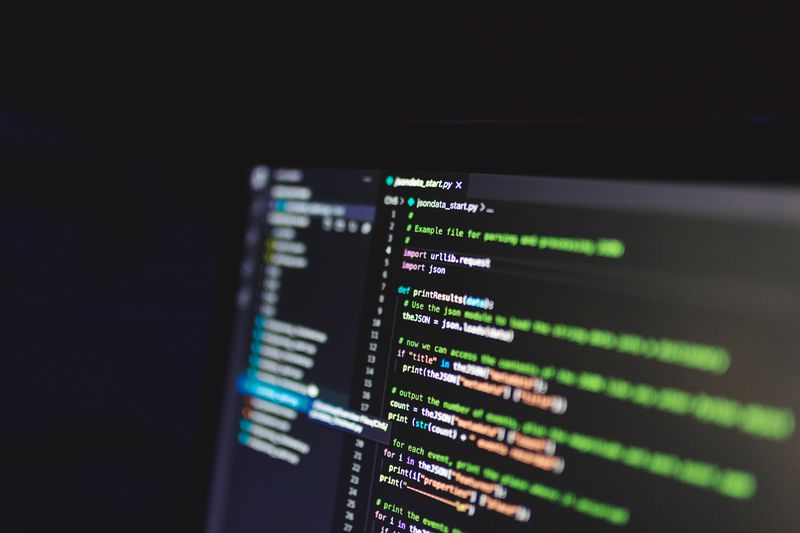 Programming code on a computer screen in a dark room, showcasing technology and IT expertise.