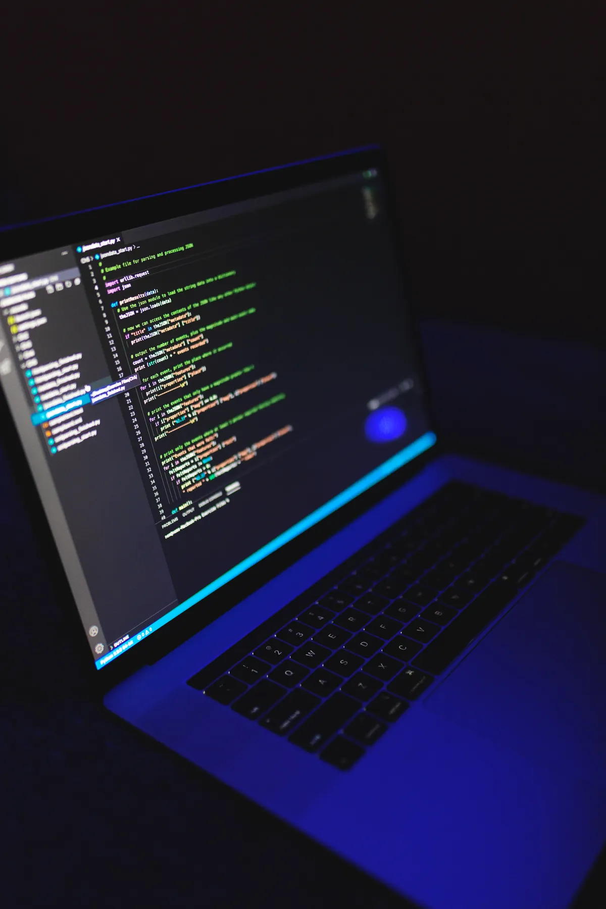 A laptop screen displaying lines of code, representing the JSON alert payload that carries a TradingView signal to Interactive Brokers.