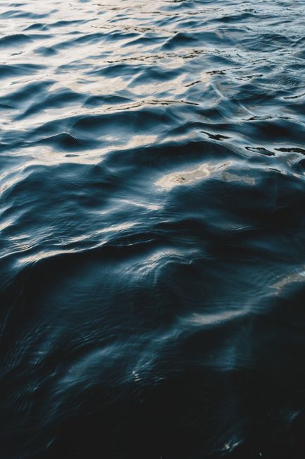 High angle of blue wavy water of deep ocean with reflection of daylight