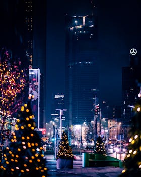 Illuminated Warsaw cityscape at night with Christmas trees and skyscrapers creating a festive atmosphere.