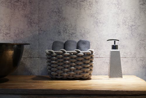 Woven Basket and Soap Dispenser on Brown Wooden Table