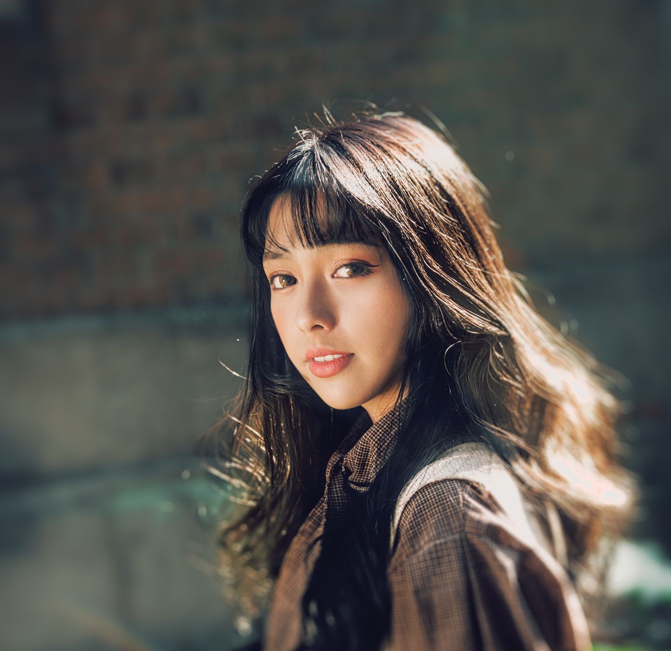 Portrait of a young woman with long hair, captured outdoors in natural light.