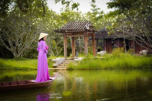 A Woman in Traditional Clothes Standing on a Boat