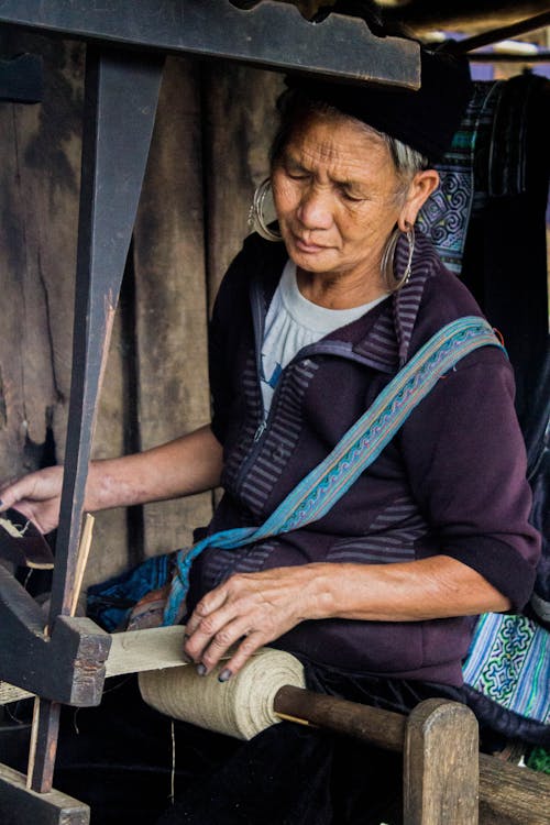 A Hardworking Woman Weaving a Textile