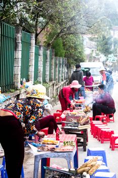 Busy scene of street vendors and customers at a food market in Ho Chi Minh City, Vietnam.