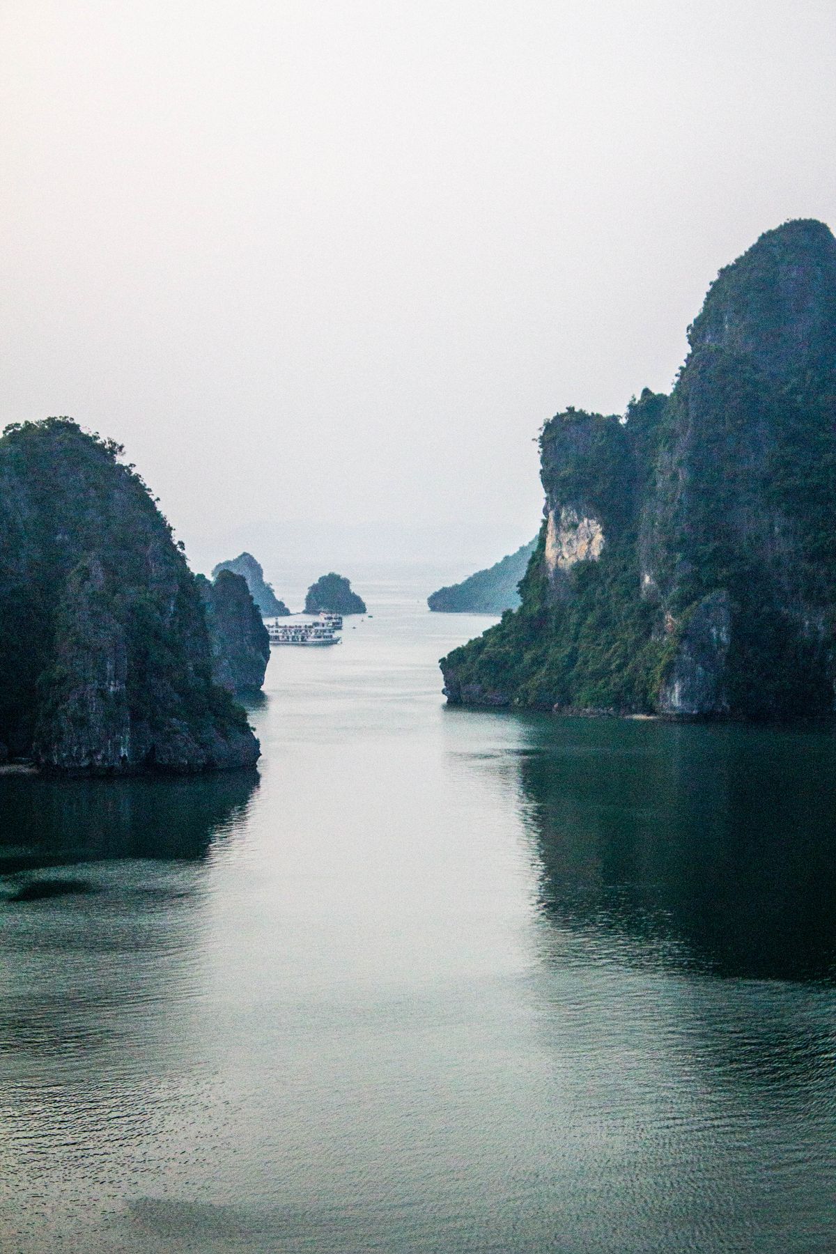 Serene landscape of karst formations in Halong Bay Vietnam with calm waters and an overcast sky