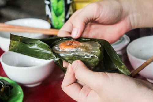 Free Hands unwrapping traditional Vietnamese banh bot loc, showcasing its shrimpy deliciousness. Stock Photo