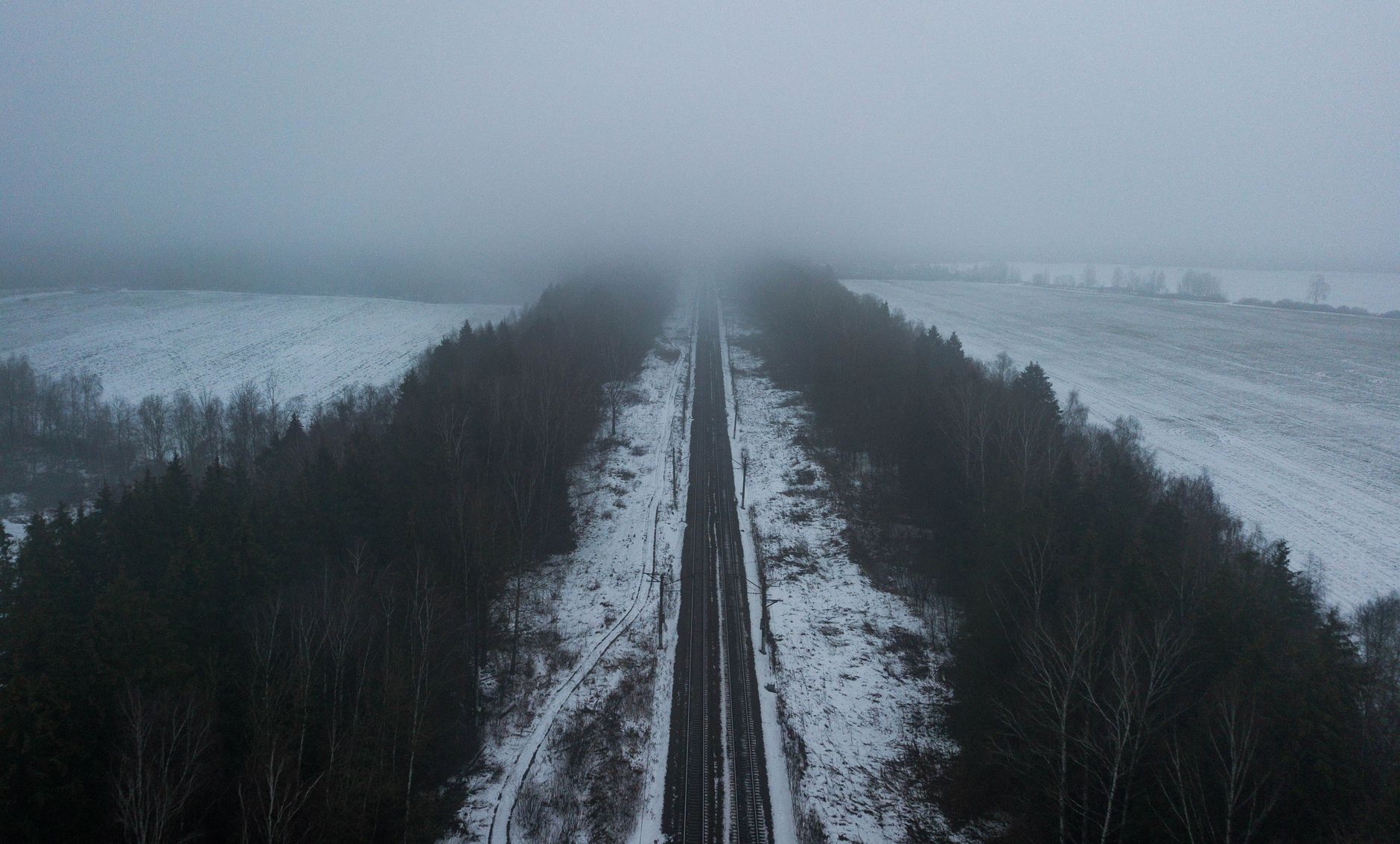 A fog-covered railway line stretches into a snowy winter landscape, evoking the remote Buckinghamshire countryside at night.