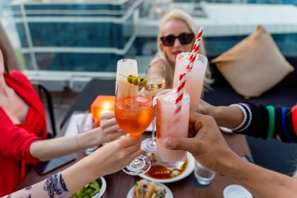 Friends toasting cocktails on a rooftop terrace — photo by Denys Gromov on Pexels