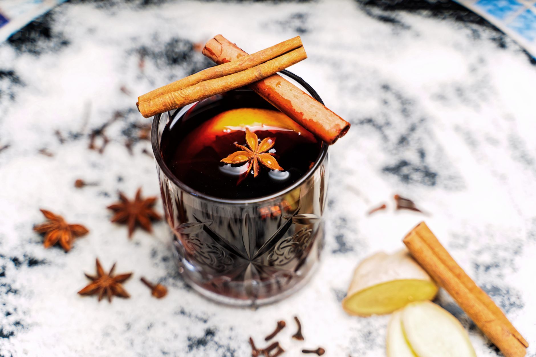 Close-up of a spiced mulled drink garnished with cinnamon sticks and star anise, perfect for cozy evenings.