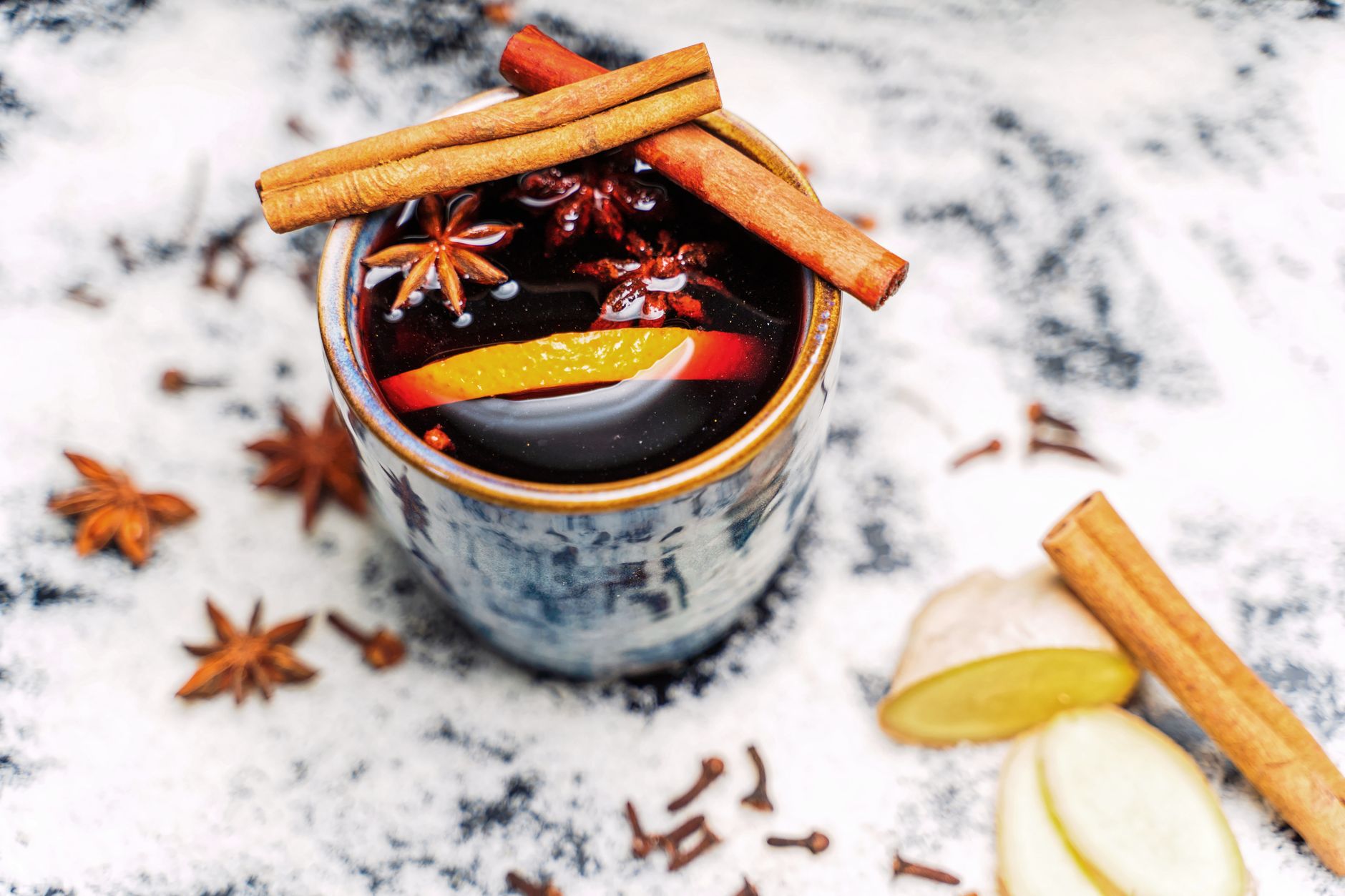 Clove tea brewed in a glass cup with whole cloves floating