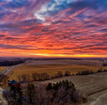 Breathtaking sunset scene over vast farmlands in Minnesota, capturing nature's vivid colors.