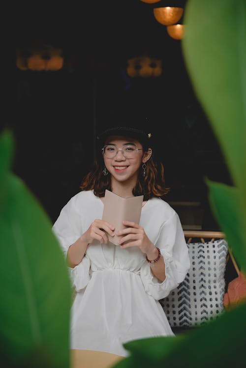 Free Woman in White Dress Holding a Wallet and Smiling Stock Photo