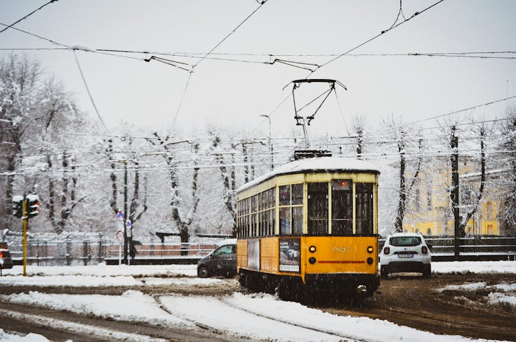 Cars And Yellow Tram On The Road