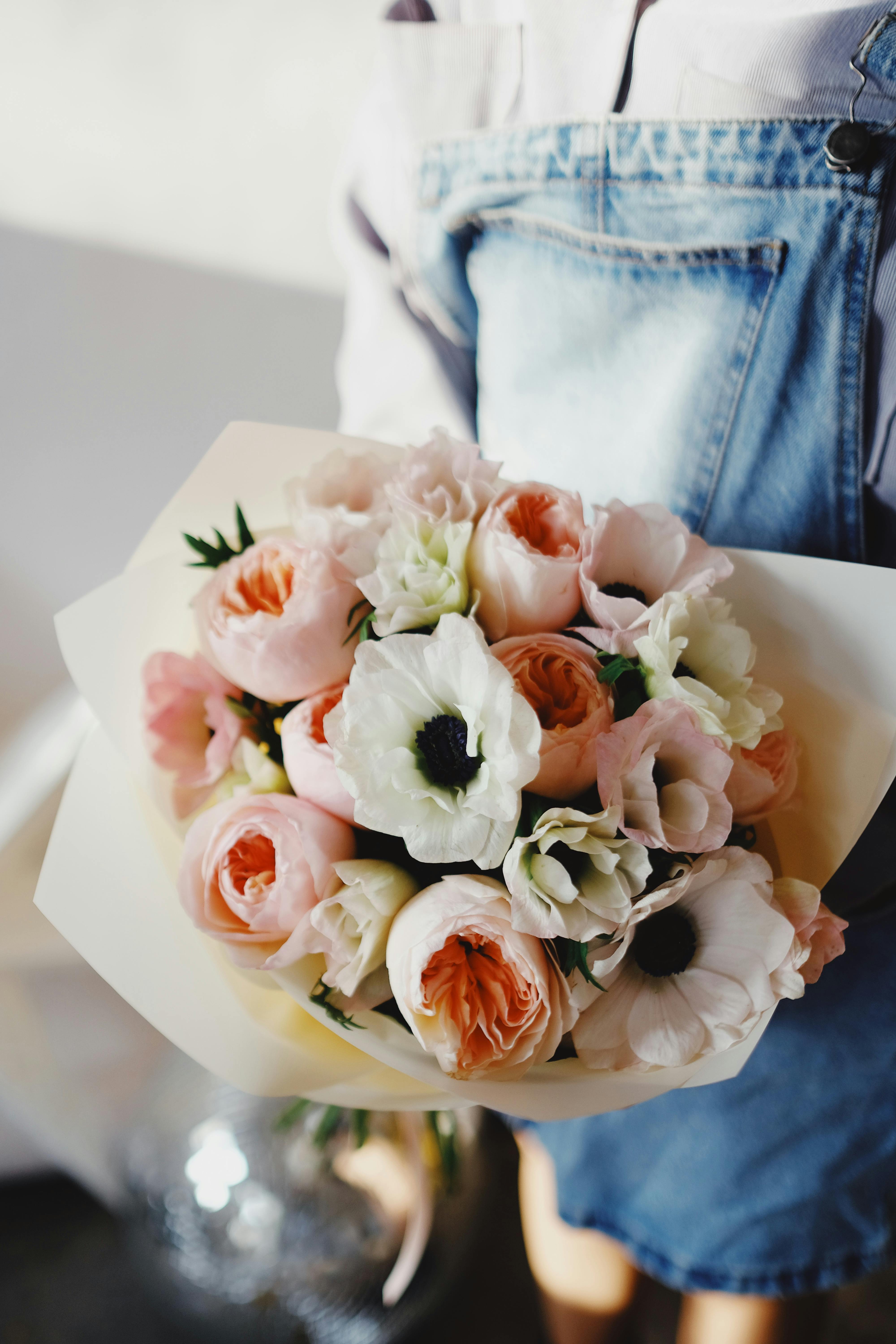 [ColoSach]-close-up-of-a-beautiful-pink-and-white-flower-bouquet-held-by-a-person-in-blue-denim-overalls.