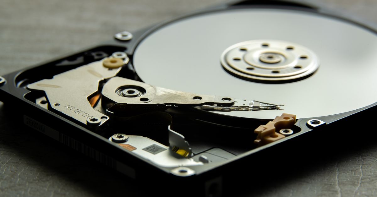 Detailed view of an open hard drive, showcasing the disk platter and actuator arm.