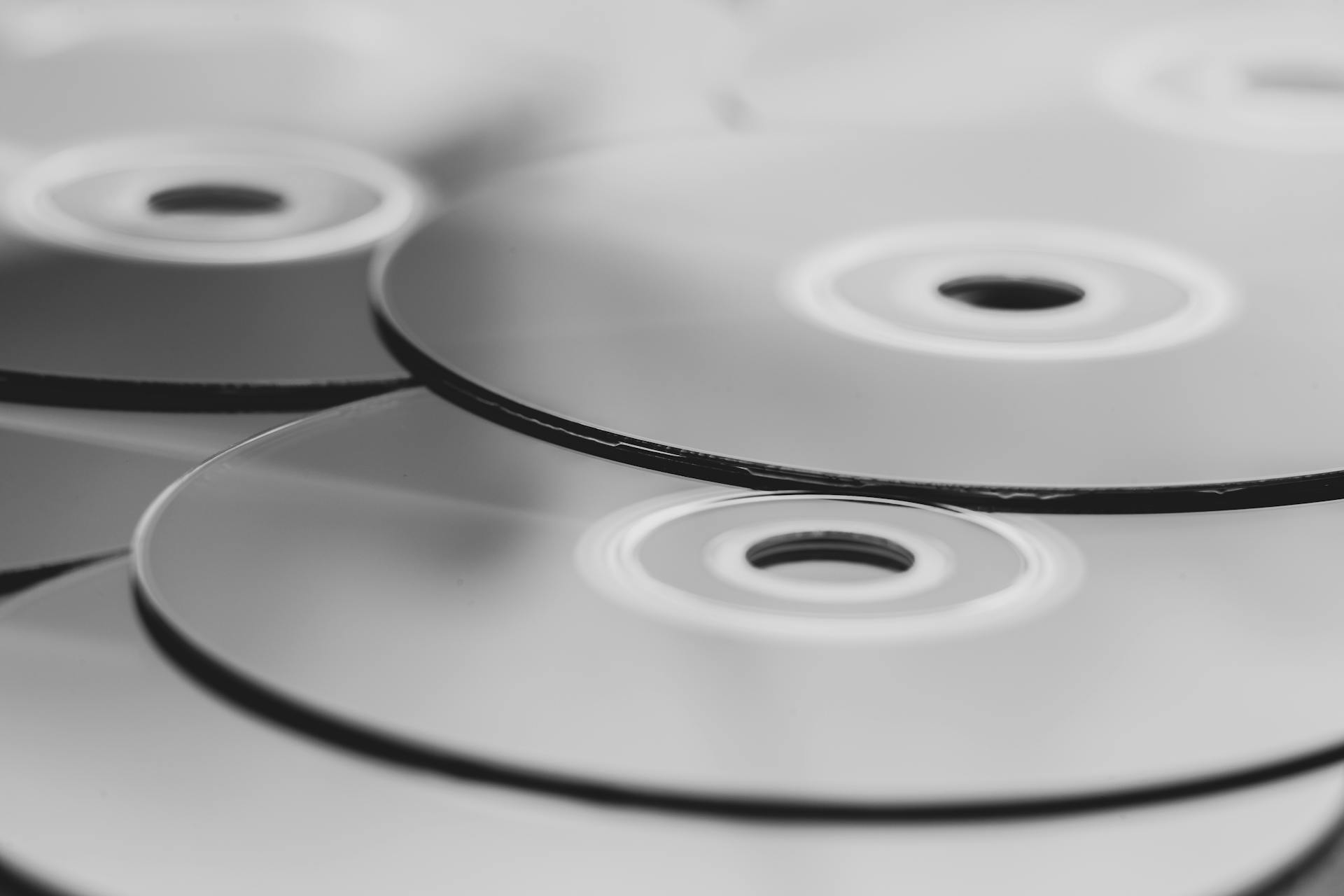 Monochrome close-up view of stacked optical discs. Minimalist design in grayscale.