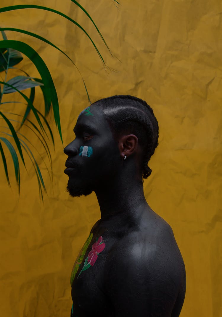 Black Guy With Painted Face And Body On Yellow Surface