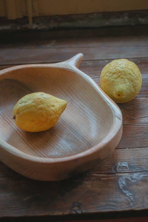 Free Yellow Lemons on Brown Wooden Bowl and Table Stock Photo