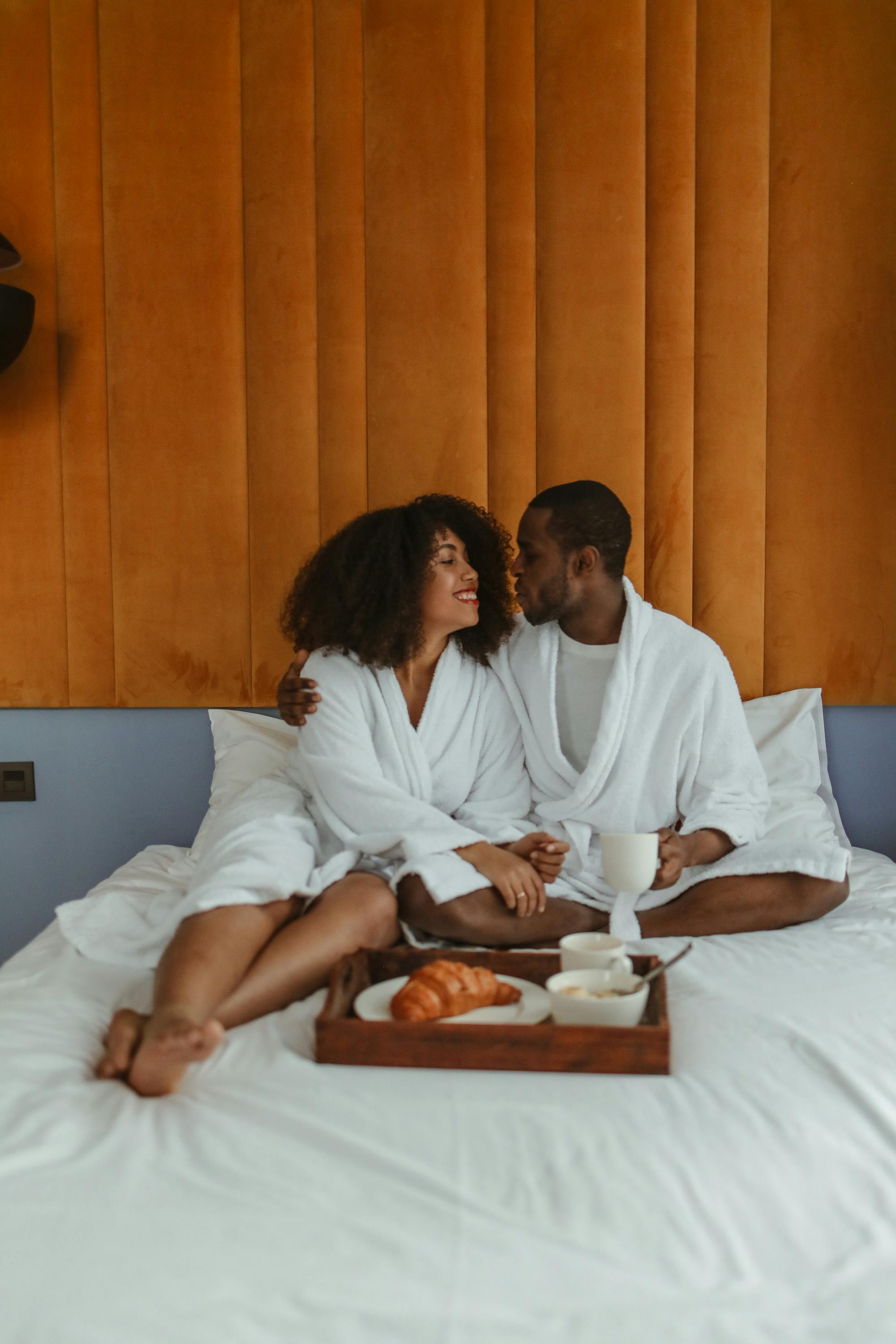 couple wearing white bathrobes while facing each other