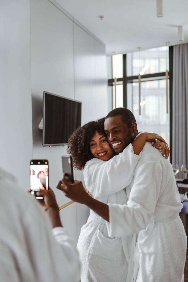 Man And Woman In Bathrobes Taking Selfie