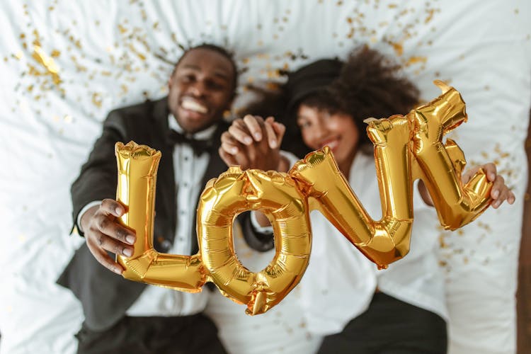 A Couple Holding Love Balloons