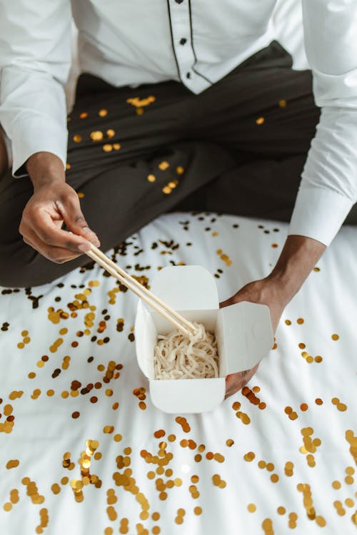 A Person Holding White Chopsticks and White Food Box