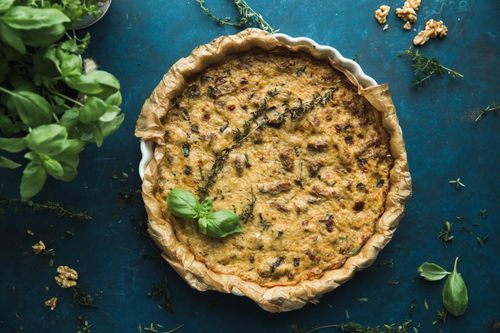 Free Delicious homemade quiche with fresh herbs on rustic blue surface, perfect for culinary presentations. Stock Photo