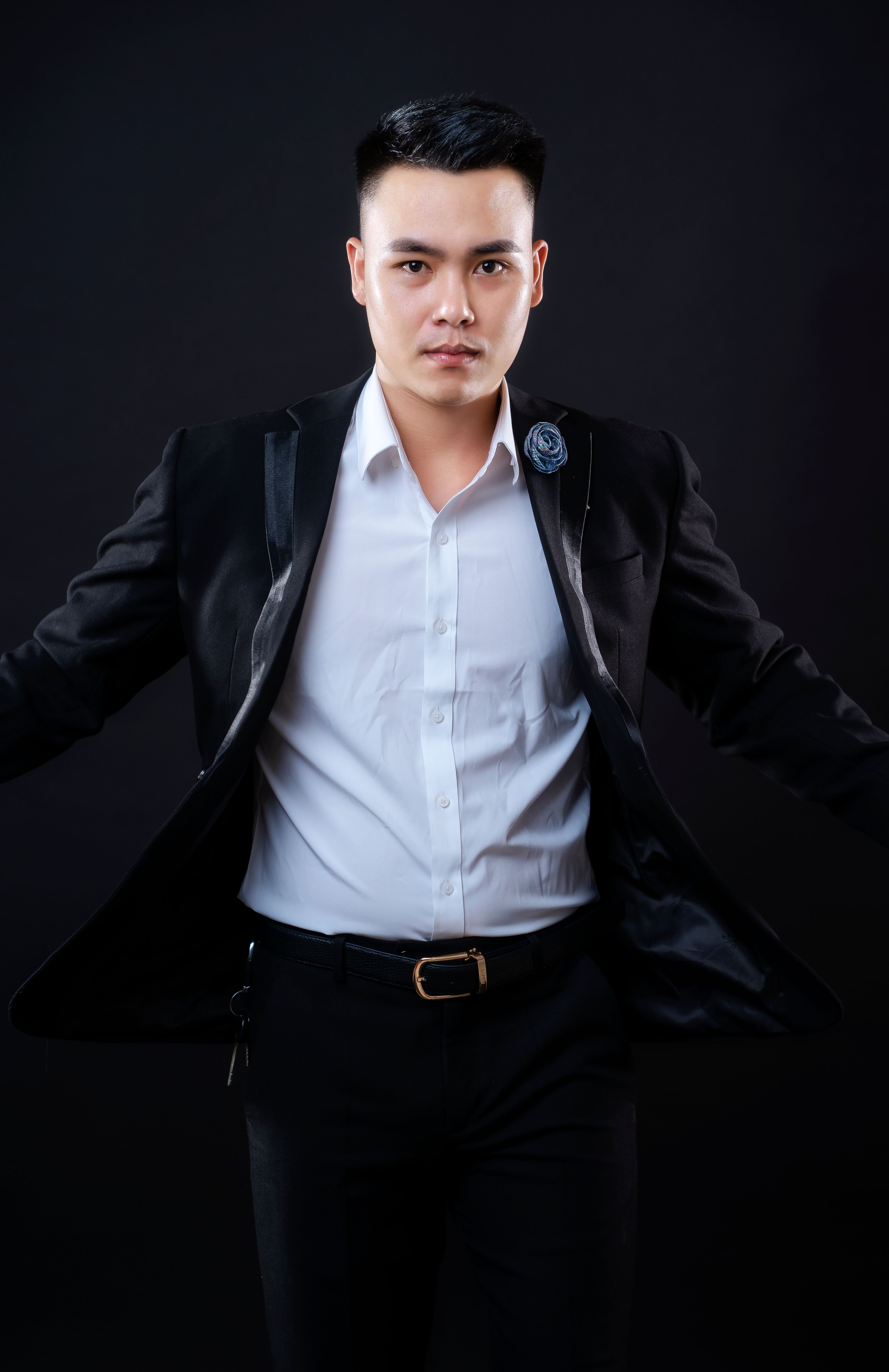 Portrait of a confident Asian man in a suit, studio setting.