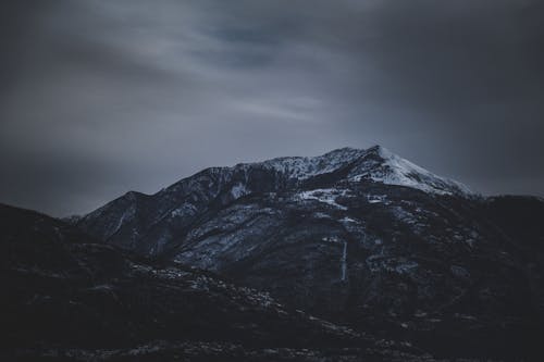 Huge mountains under cloudy sky in evening