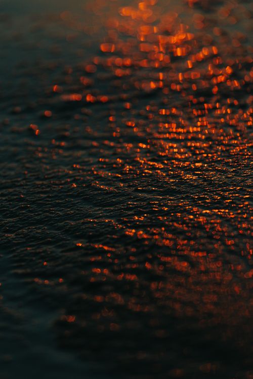 Free A captivating abstract view of dawn light reflecting on the ocean surface, creating a warm and textured effect. Stock Photo