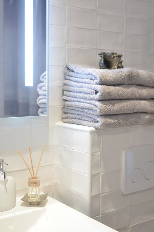 Fragrance sticks and towels in contemporary bathroom