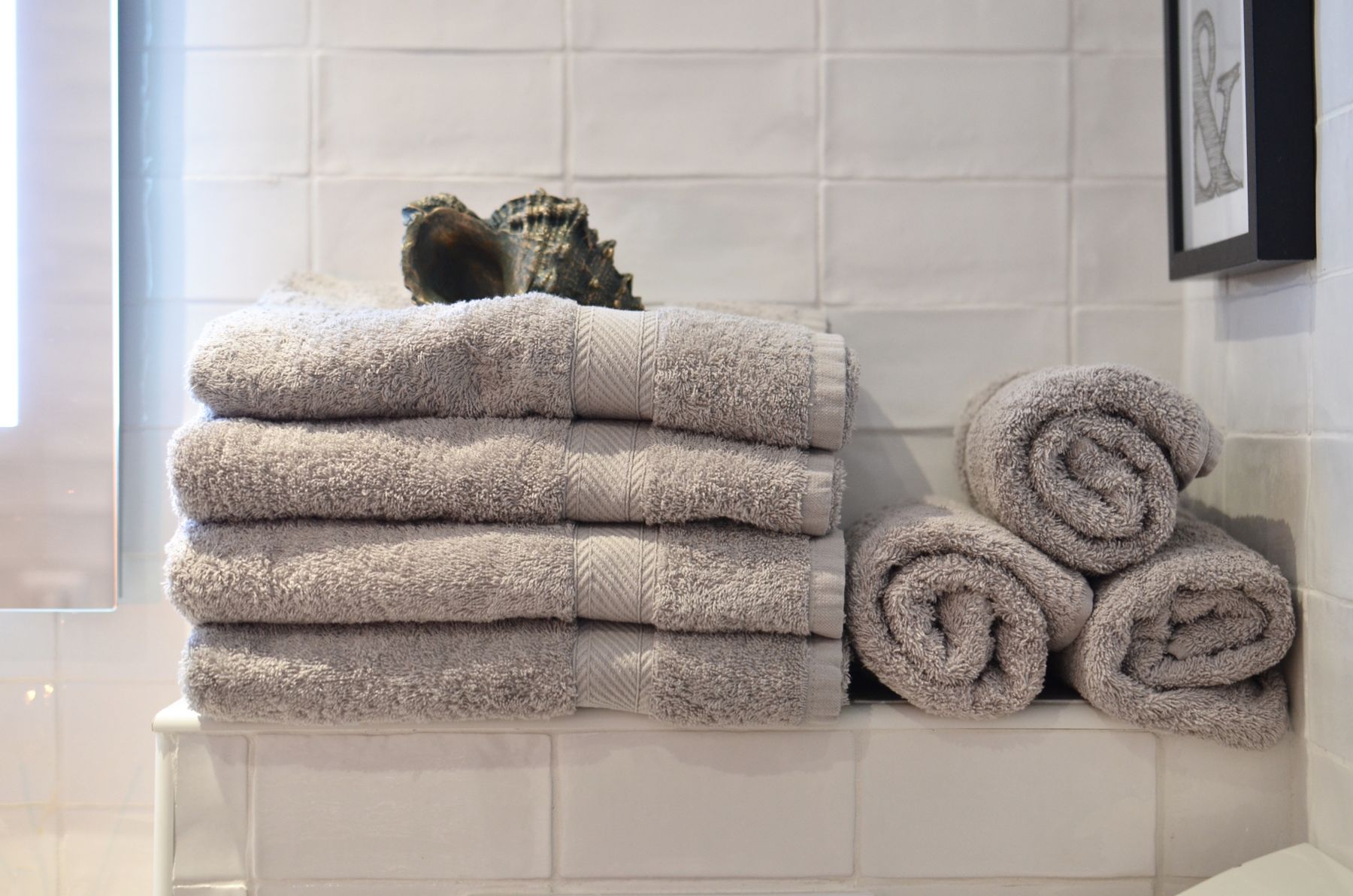 Bathroom shelving with folded towels and organized linen storage