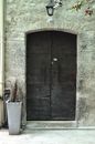 Shabby wooden doors of old stone residential house located on city street in daytime