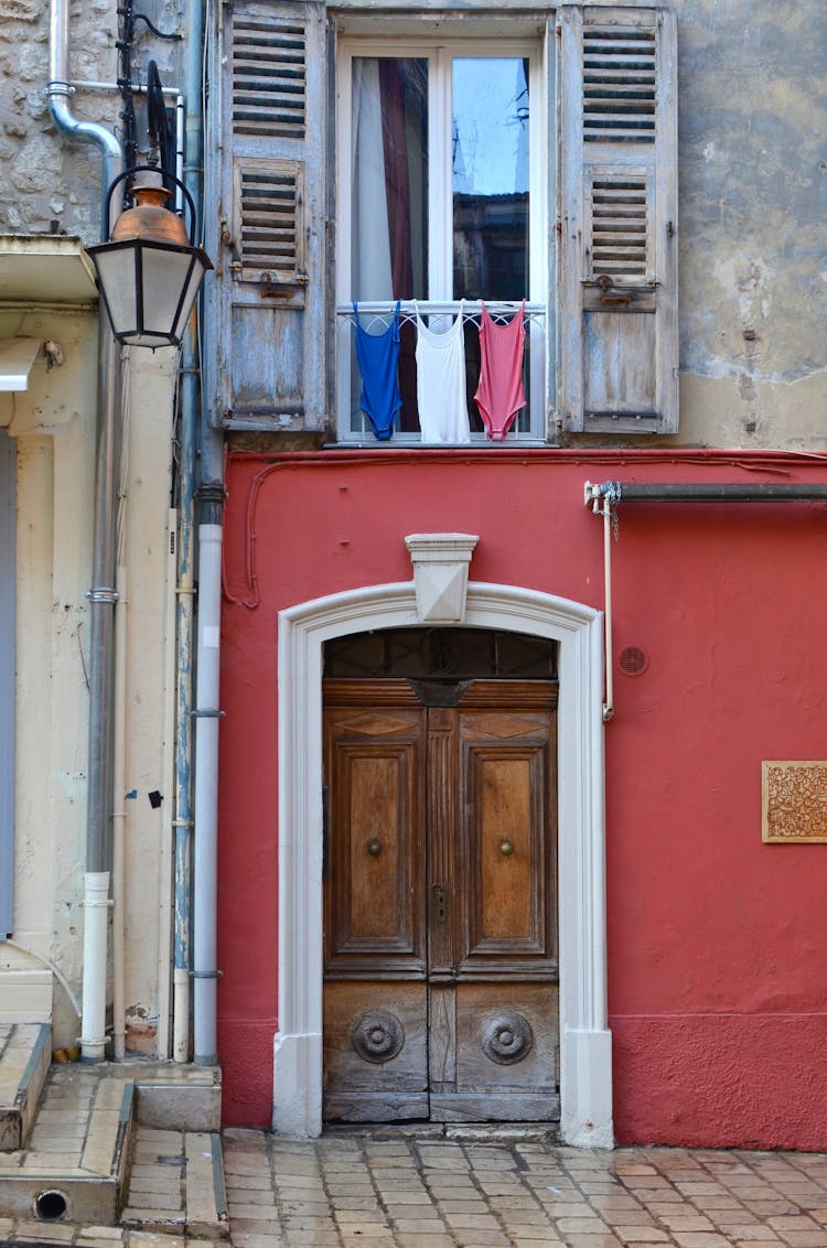 Facade Of Old Residential Building With Wooden Windows And Doors On Paved Street